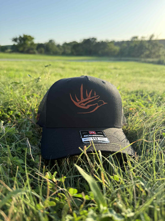 Black Richardson 112 cap with burnt orange Blaze logo stitched on front, placed on grass field
