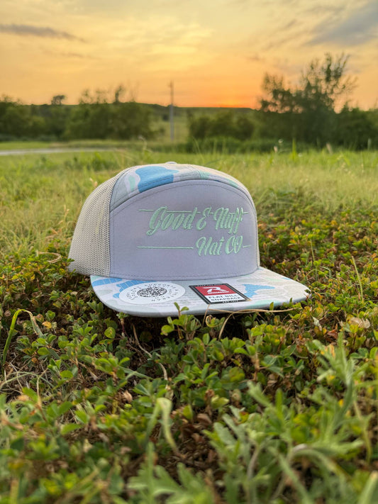 FROSTBITE pale blue camo mesh trucker hat with mint antler logo on grass at sunset
