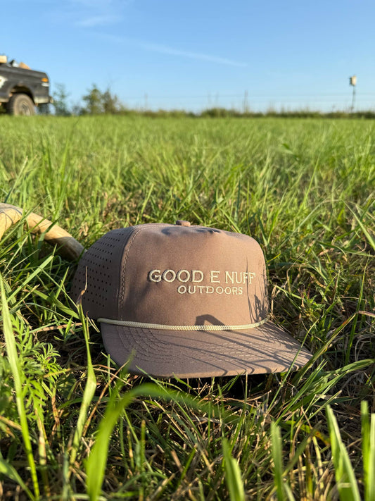 Marsh Tracker tan outdoor hat with breathable panels and rope crown in grassy field