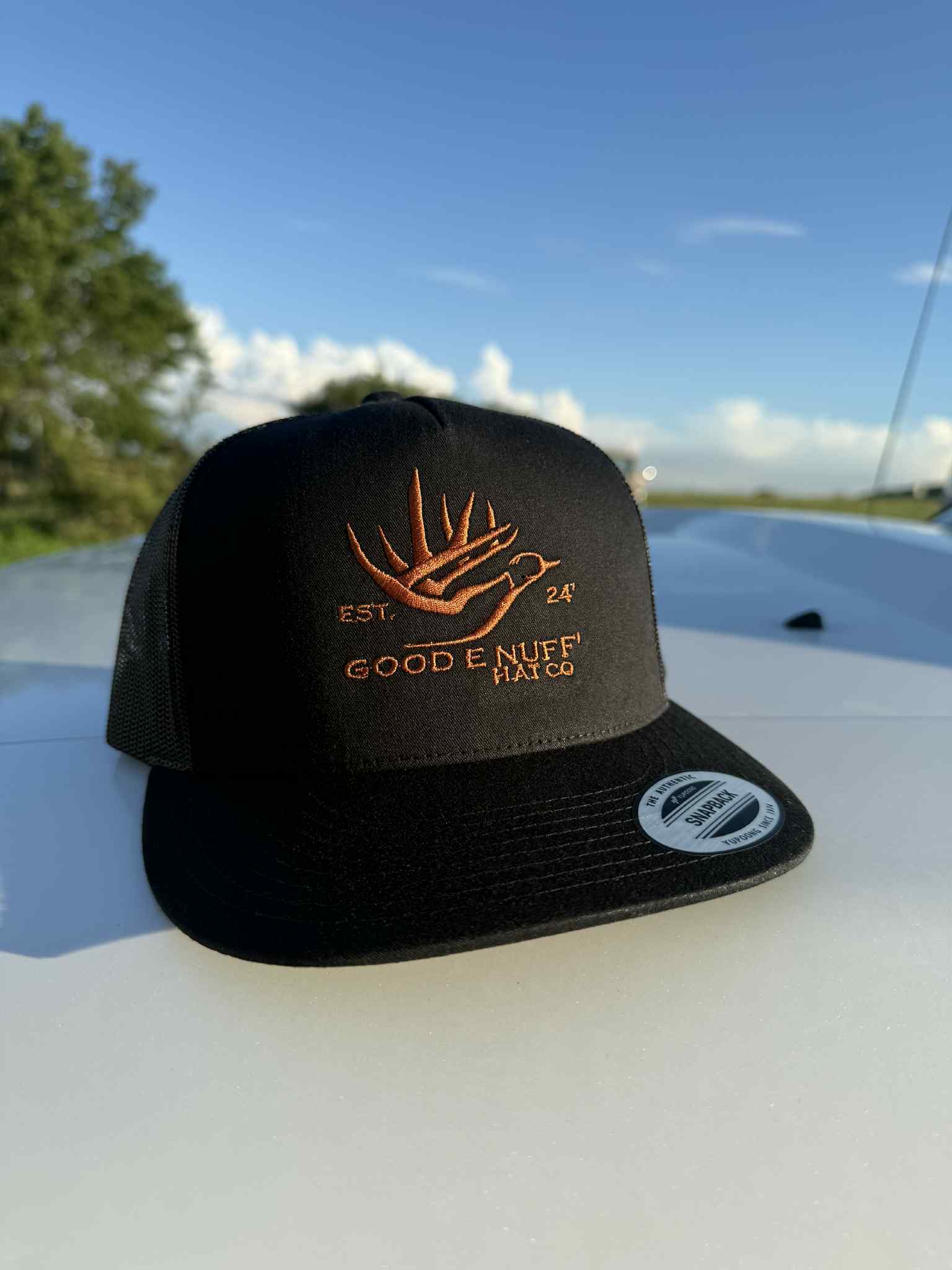 Black Yupoong snapback hat with embroidered GEN logo featuring antler and bird design, structured crown and mesh back.