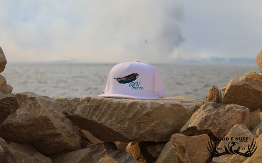 Free Flight hat with blue teal duck feather embroidery on charcoal snapback, outdoor setting.