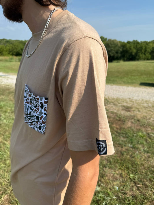 Beige Good E Nuff’ Pocket Tee with custom camo smoker’s pocket and short sleeves worn outdoors