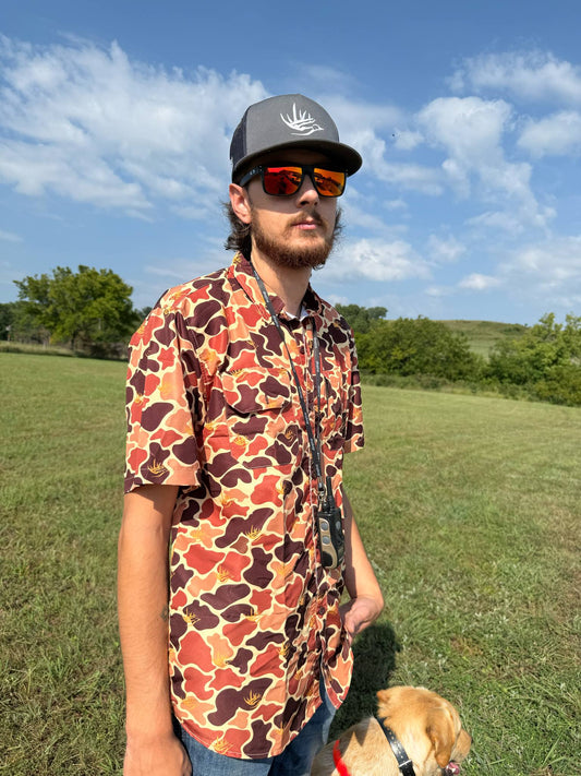 Man wearing Good E Nuff Fishing shirt with custom GEN camo and antler logo outdoors with dog